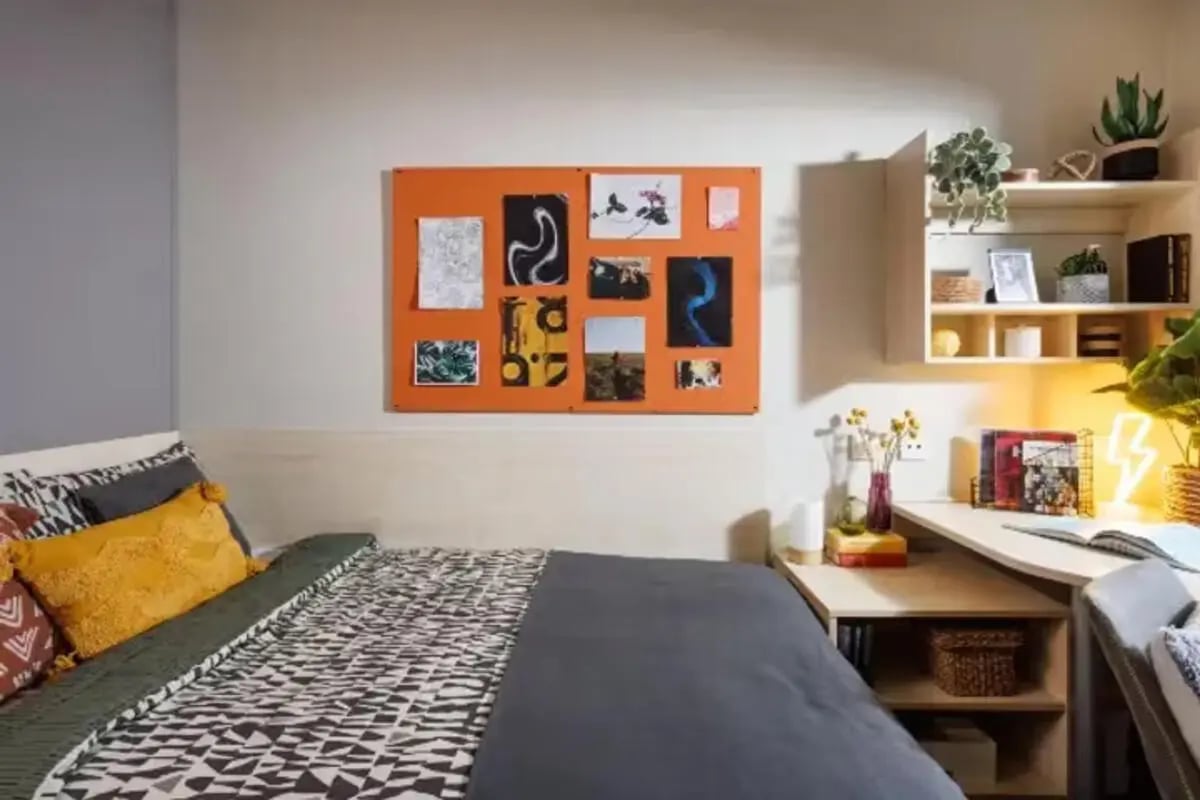 Bed with patterned bedding and corkboard study area Bedroom at Riverside Point in Nottingham Student Accommodation