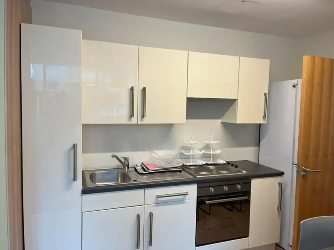 White cabinets sink stove and oven kitchen at Emily Bowes Court in London Student Accommodation