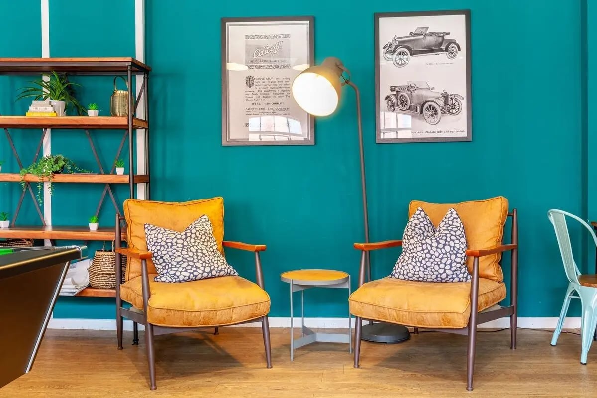 Two orange armchairs with patterned pillows living room at Calcott Ten in Coventry Student Accommodation