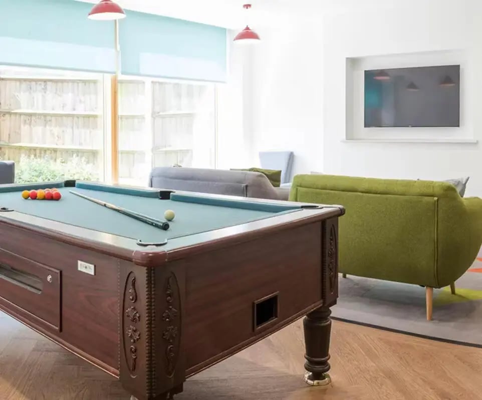 Pool table billiard balls cue red lamps living area Image at Charles Morton Court in London Student Accommodation