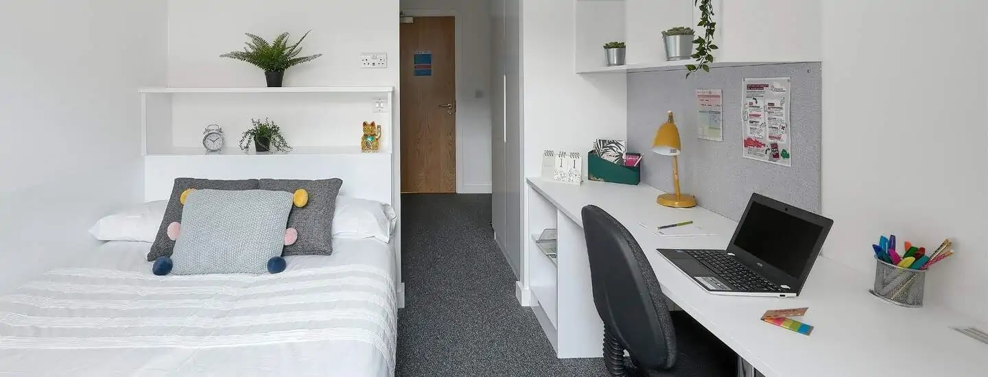 Bed desk laptop and pens bedroom study area at Selly Oak Apartments in Birmingham Student Accommodation
