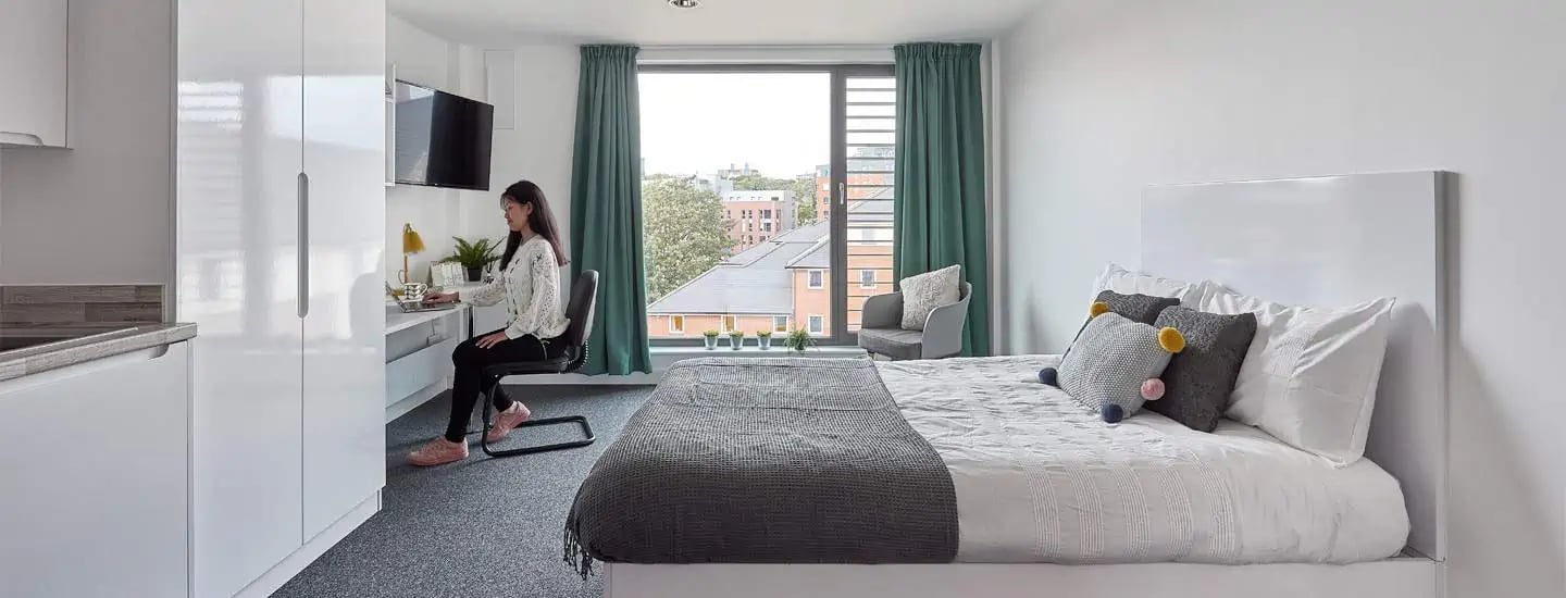 Student desk bed and kitchen area bedroom at Selly Oak Apartments in Birmingham Student Accommodation