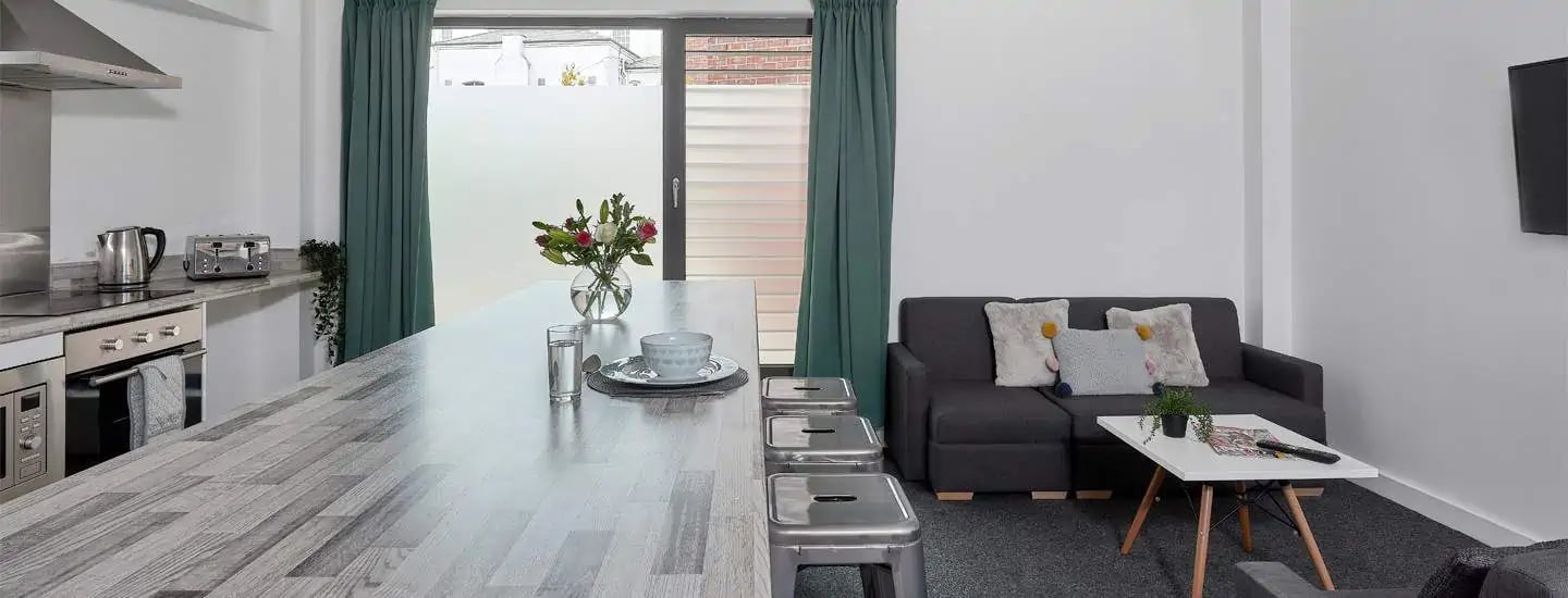 Kitchen island with seating and sofa living area at Selly Oak Apartments in Birmingham Student Accommodation