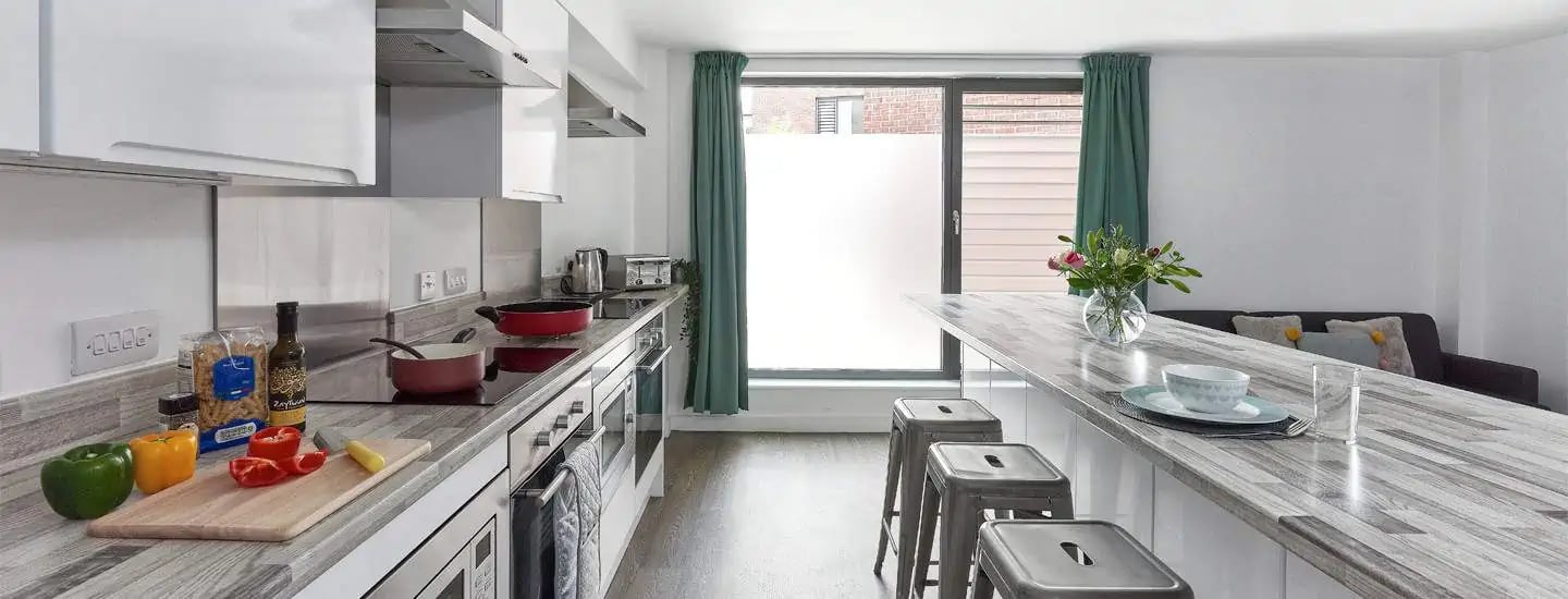Kitchen counters with food and stools kitchen at Selly Oak Apartments in Birmingham Student Accommodation