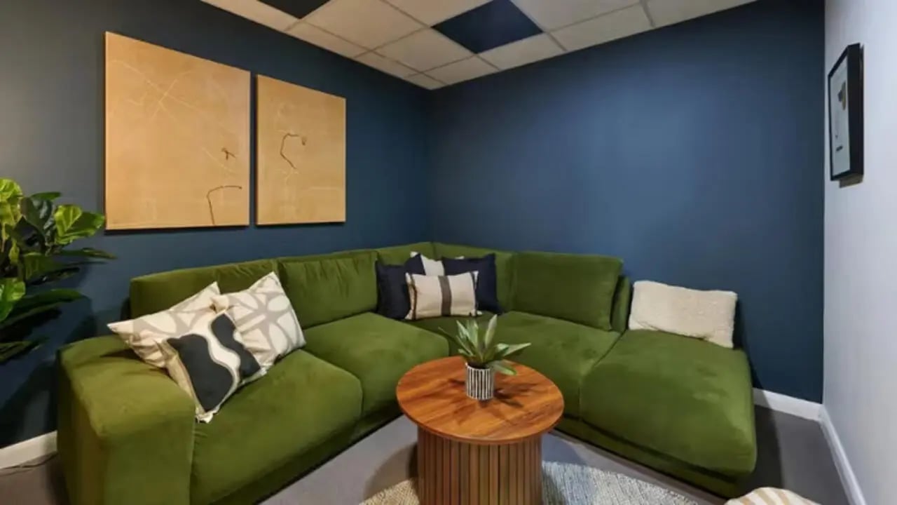 Green sectional sofa wooden coffee table art living room at The Hub in London Student Accommodation