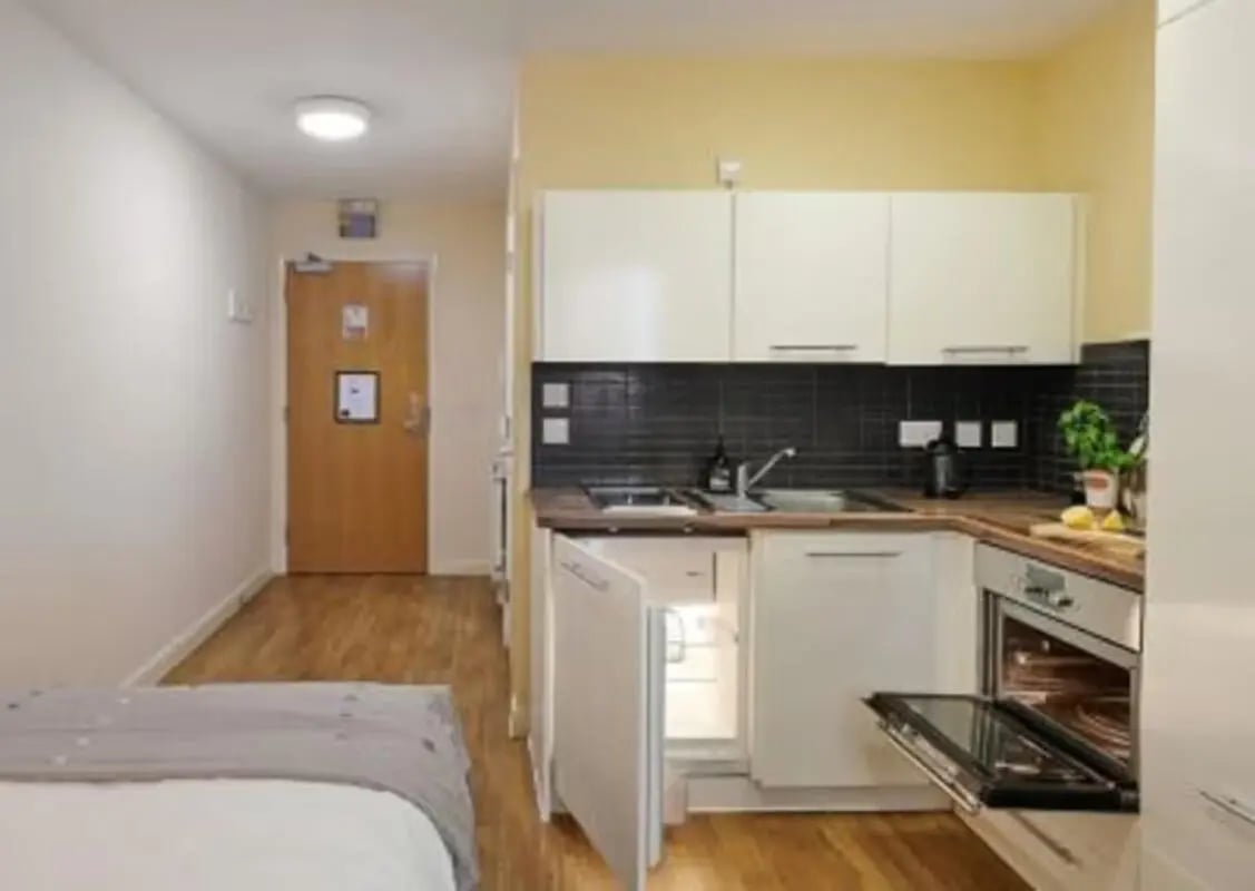 Bed fridge oven sink kitchen living room at The Hub in London Student Accommodation