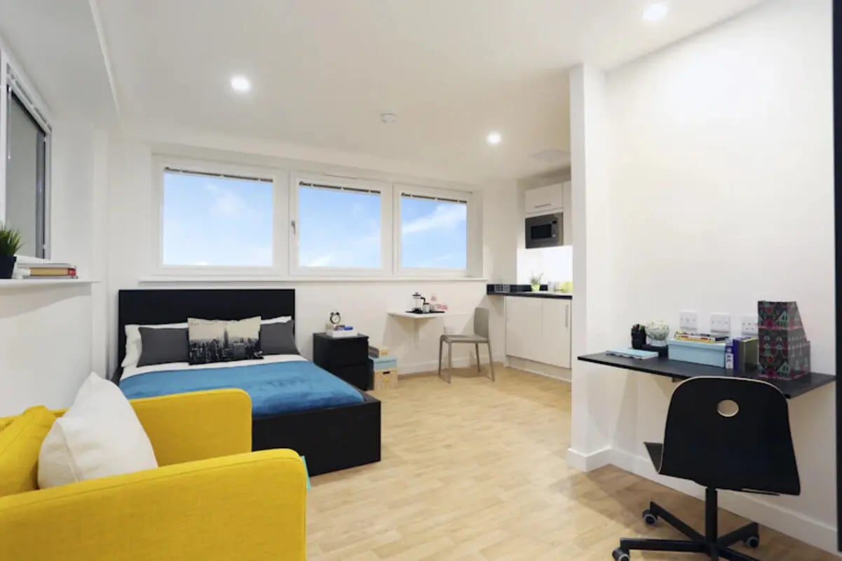 Bed blue chair and desk study area at Keele House in Newcastle Under Lyme Student Accommodation