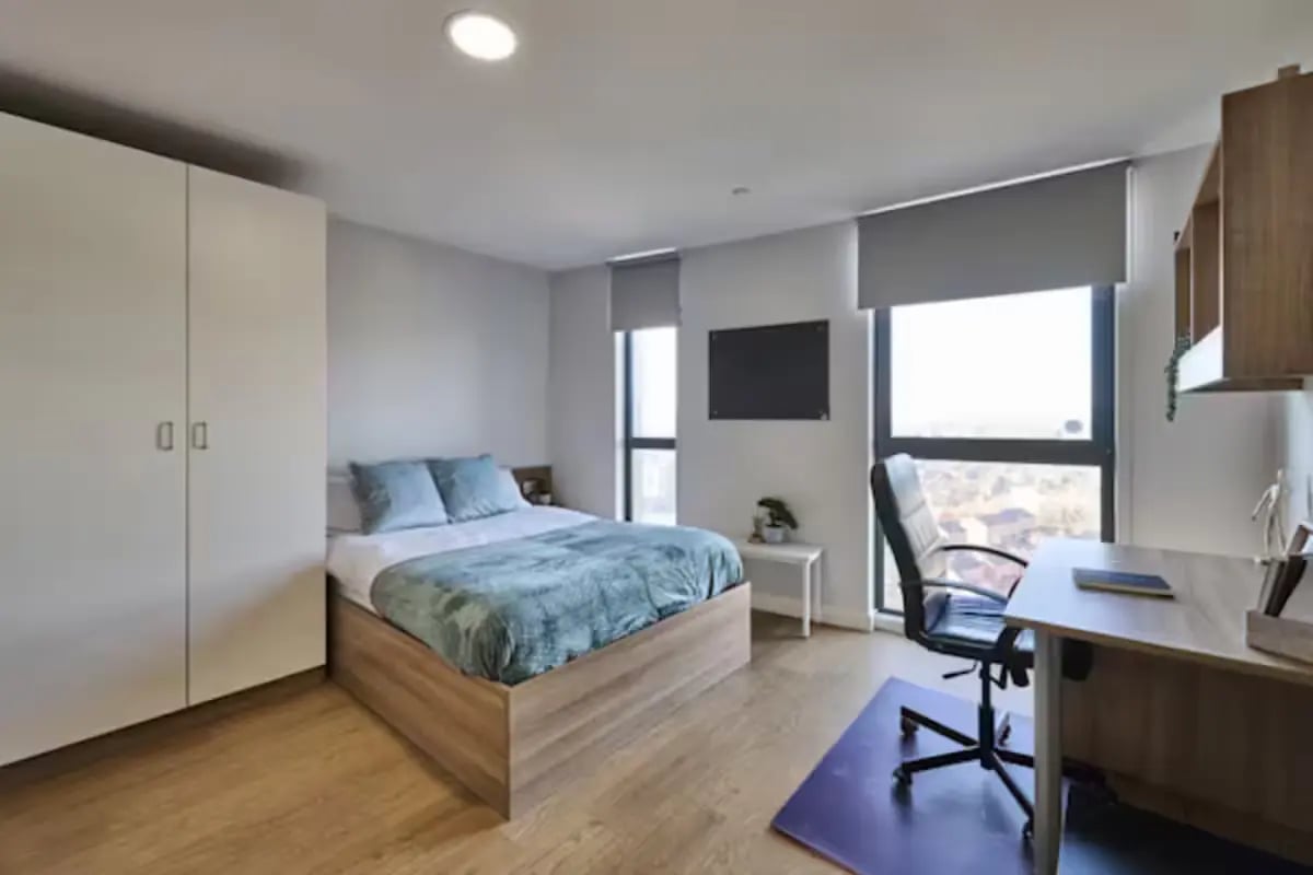 Bed wardrobe desk chair and window bedroom at The Summit Leicester in Leicester Student Accommodation