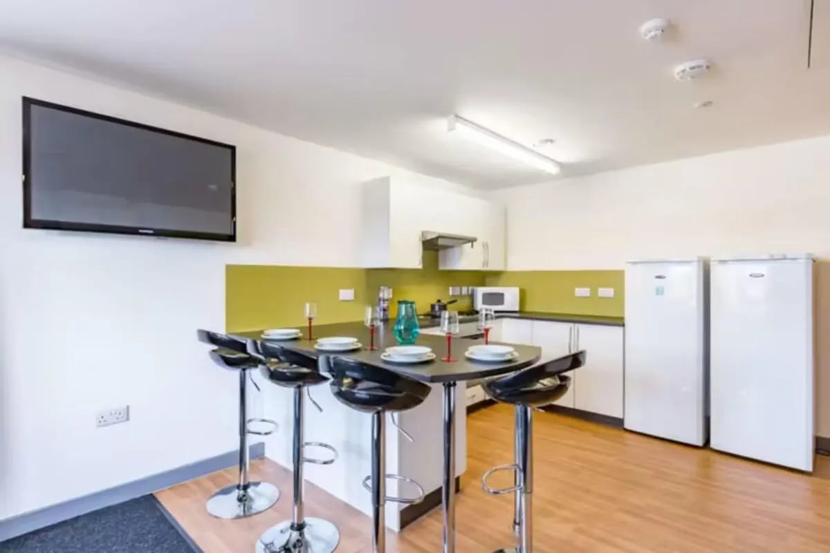 Bar with stools TV and fridges kitchen at Russell View in Nottingham Student Accommodation