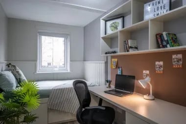 Bed desk chair shelves with laptop books study area at Meadow Court in Edinburgh Student Accommodation