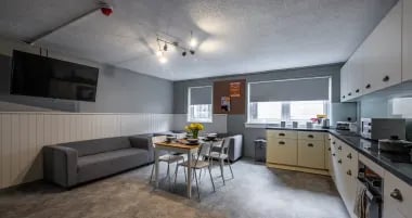 Sofa dining table kitchen appliances shared living kitchen at Meadow Court in Edinburgh Student Accommodation