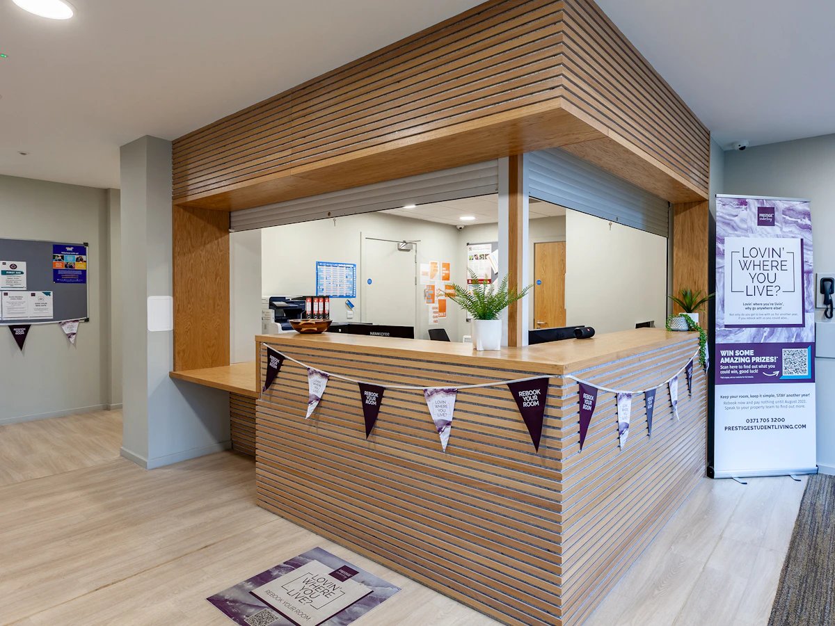 Reception desk with plants and banners reception area at Straits Meadows in Edinburgh Student Accommodation