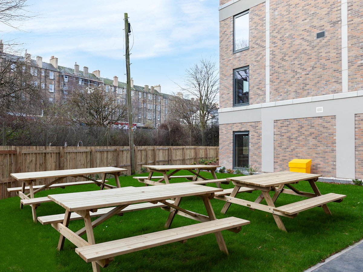 Picnic tables on grass exterior. at Straits Meadows in Edinburgh Student Accommodation