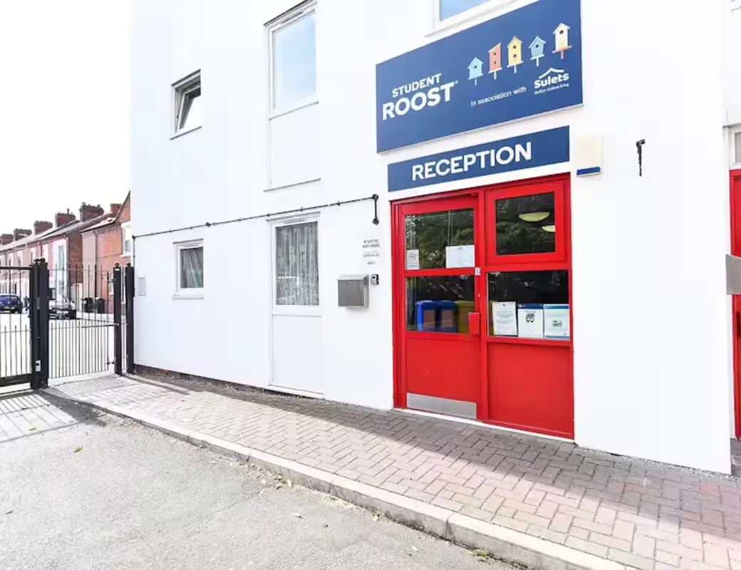 Red reception doors with signage and gate exterior at Queens Court Leicester in Leicester Student Accommodation