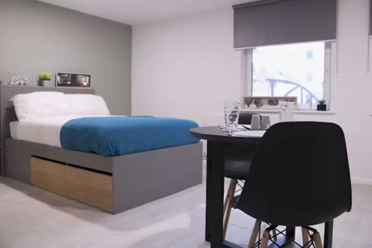 Bed with blue blanket and desk area bedroom at Queens Court Leicester in Leicester Student Accommodation