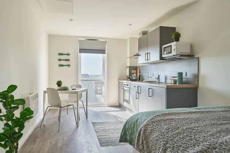 Kitchen dining area with table chairs and bed studio apartment at The Bank Southampton in Southampton Student Accommodation