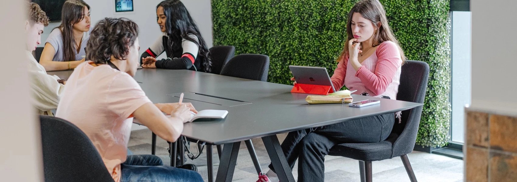Students studying at a table with green wall study area at Chapter Ealing in London Student Accommodation