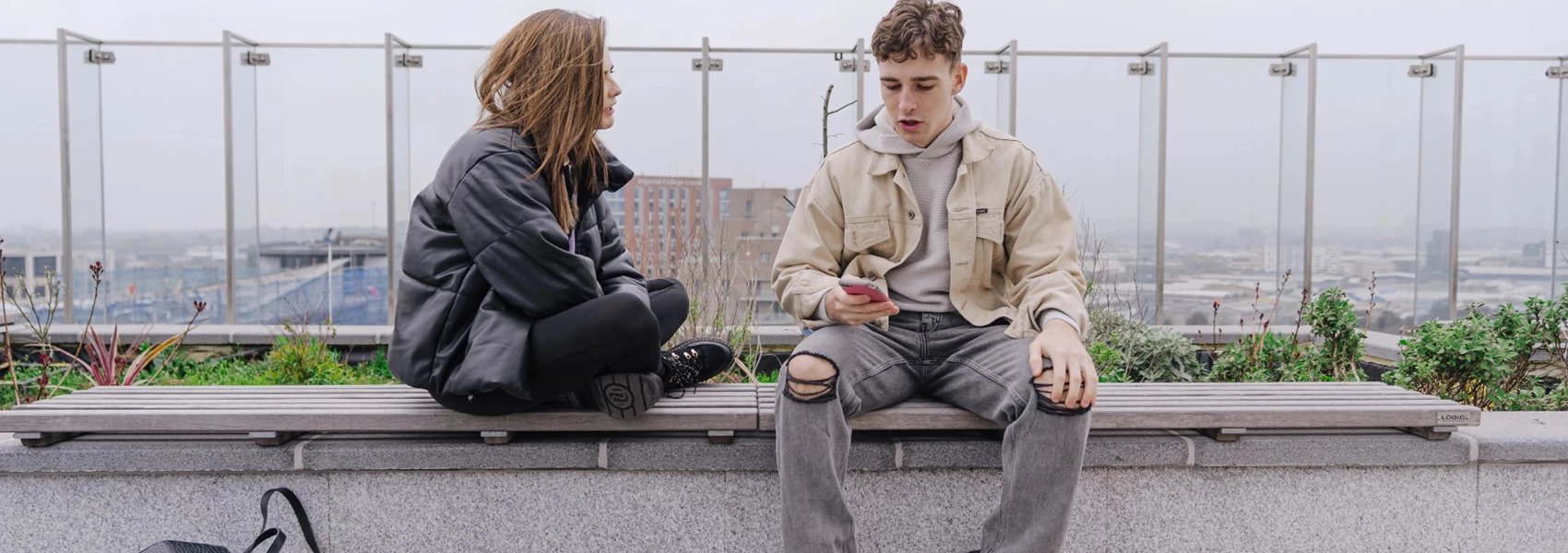 Students sitting on bench on rooftop terrace exterior at Chapter Ealing in London Student Accommodation