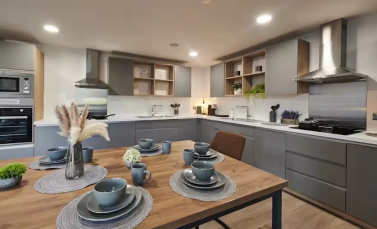 Wooden table with place settings and gray cabinets kitchen at York House in Nottingham Student Accommodation