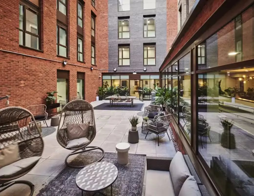 Courtyard with hanging chairs and tables outdoor area at York House in Nottingham Student Accommodation