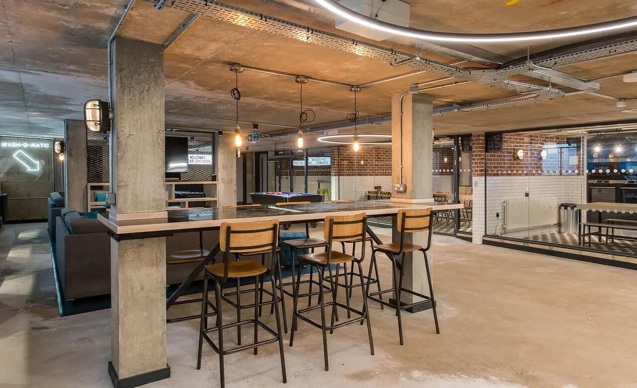 Bar area with stools and kitchen beyond communal area at Berkshire House Reading in Reading Student Accommodation