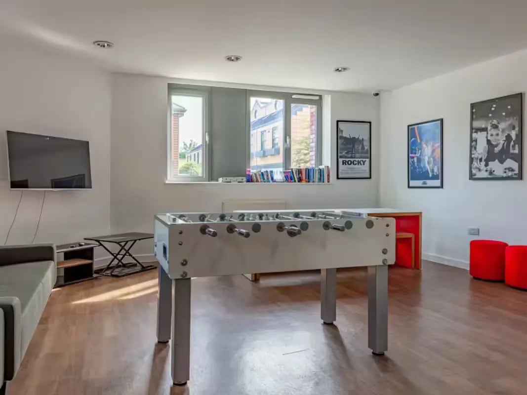 Foosball table television couch and posters living room at Central Studios - London in London Student Accommodation
