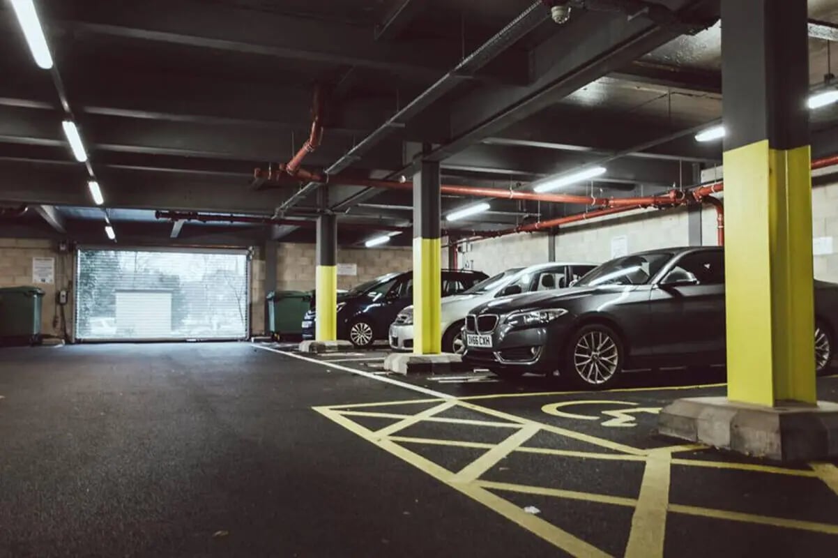 Parking lot with cars and bins exterior at Longside House Bradford in Bradford Student Accommodation