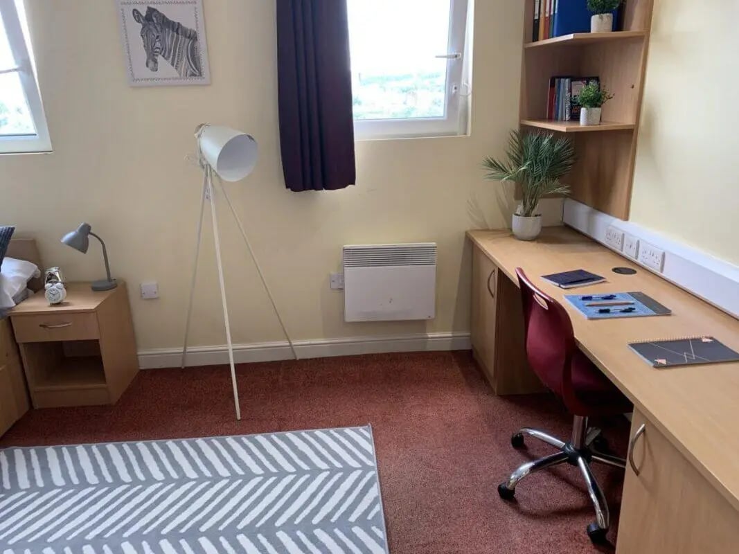 Desk lamp nightstand easel and rug study area at Longside House Bradford in Bradford Student Accommodation