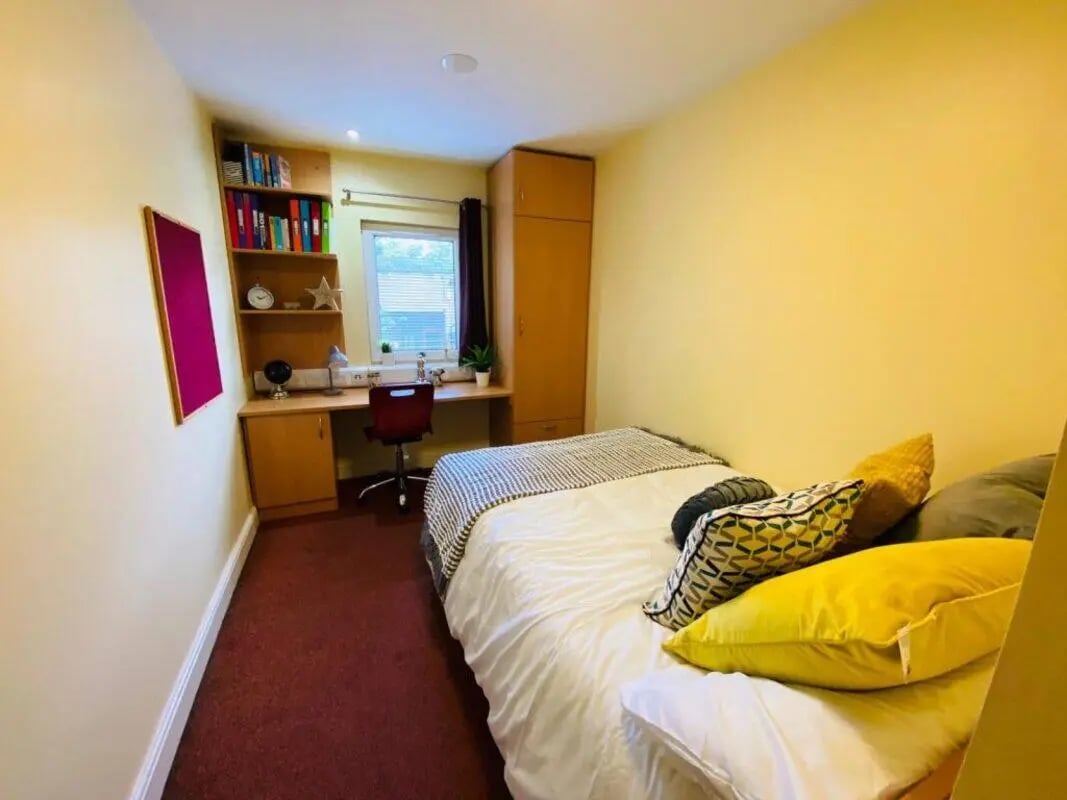Bed desk shelves closet and pillows bedroom at Longside House Bradford in Bradford Student Accommodation