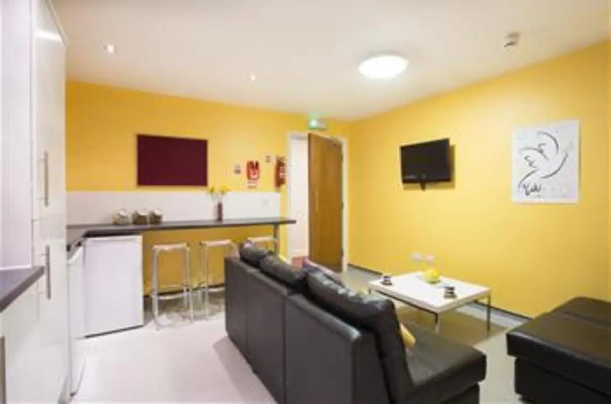 Sofa coffee table stools and kitchen living room at Longside House Bradford in Bradford Student Accommodation