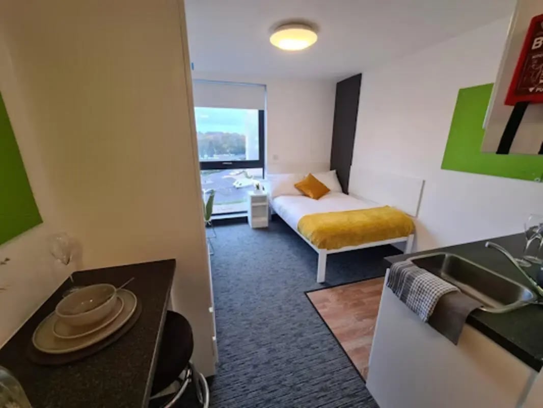 Bedside table and bed with yellow blanket bedroom at St James Point in Newcastle Upon Tyne Student Accommodation