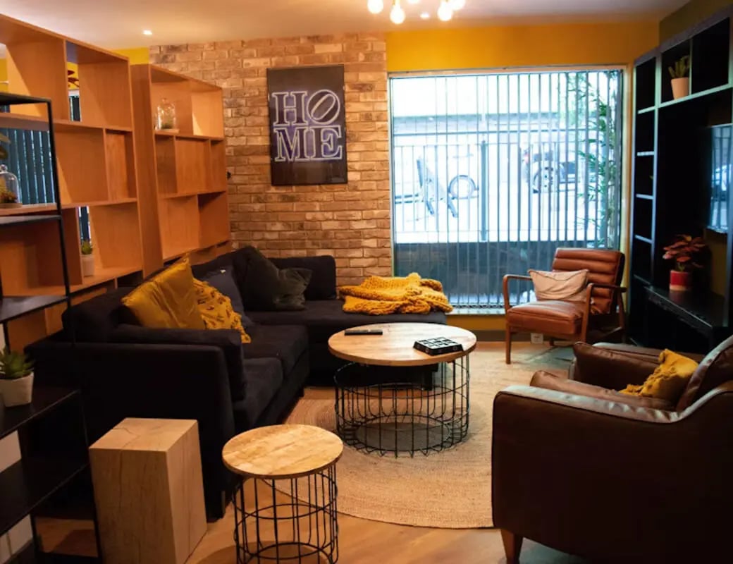 Modern living room with dark sofa and chairs living room at St James Point in Newcastle Upon Tyne Student Accommodation