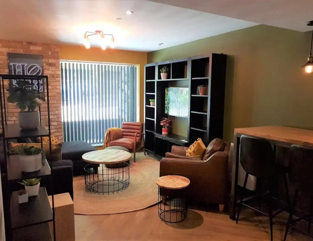 Modern living room with couches bookshelf and table. Living room at St James Point in Newcastle Upon Tyne Student Accommodation