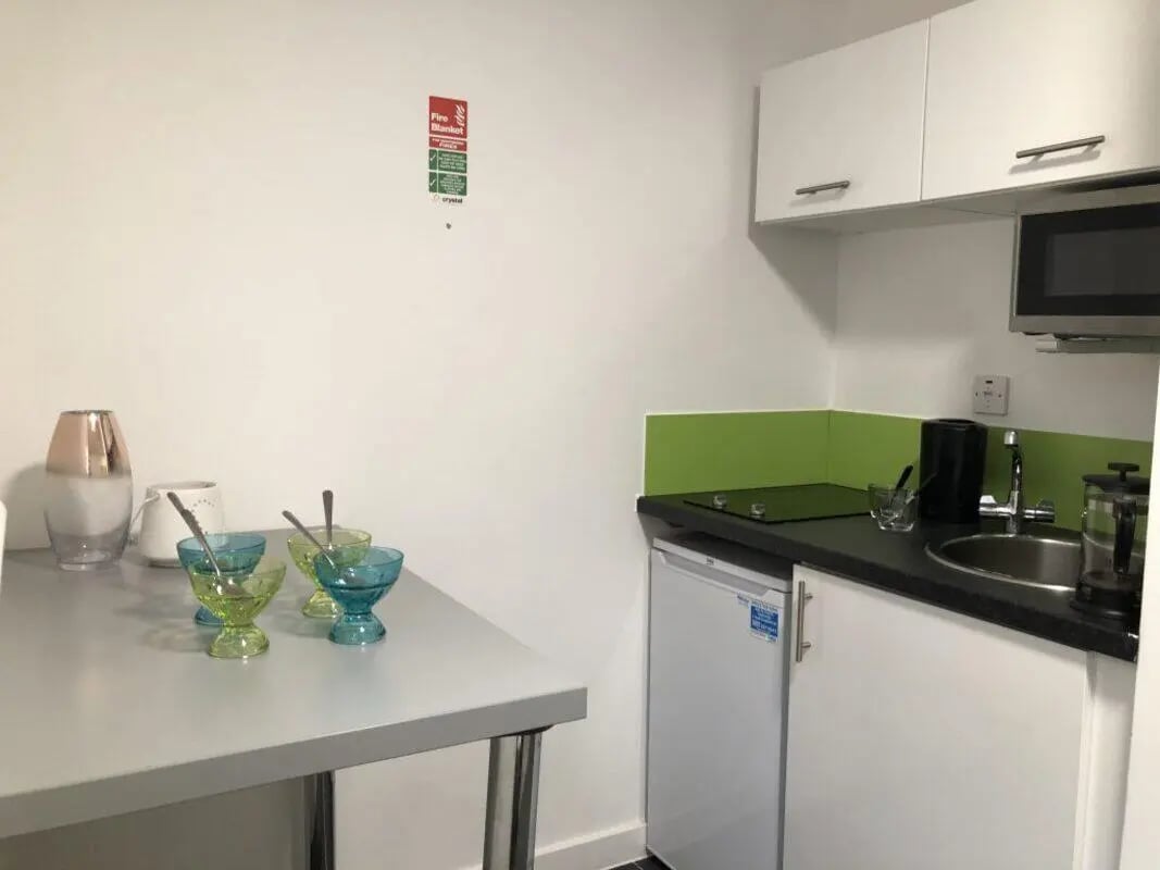 Table with bowls and mini kitchen kitchen at Tudor Studios in Leicester Student Accommodation