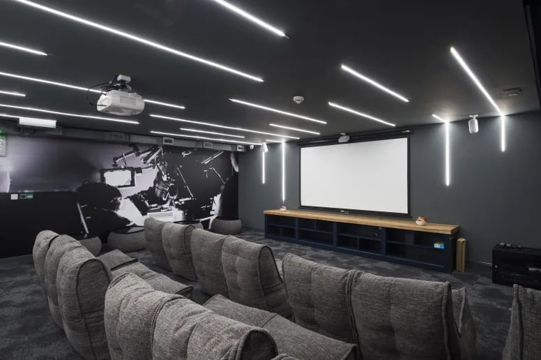 Beanbag chairs facing projector screen and mural playing area at Riverside Quay in Stirling Student Accommodation