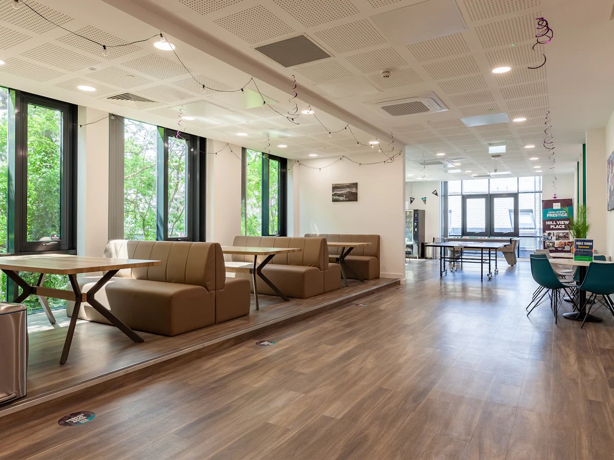 Sofa booths and tables with ping pong table communal area at Hill View Place in Exeter Student Accommodation