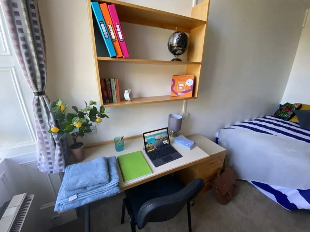 Desk bookshelf globe and bed bedroom study area at St Mary's Newcastle in Newcastle Upon Tyne Student Accommodation