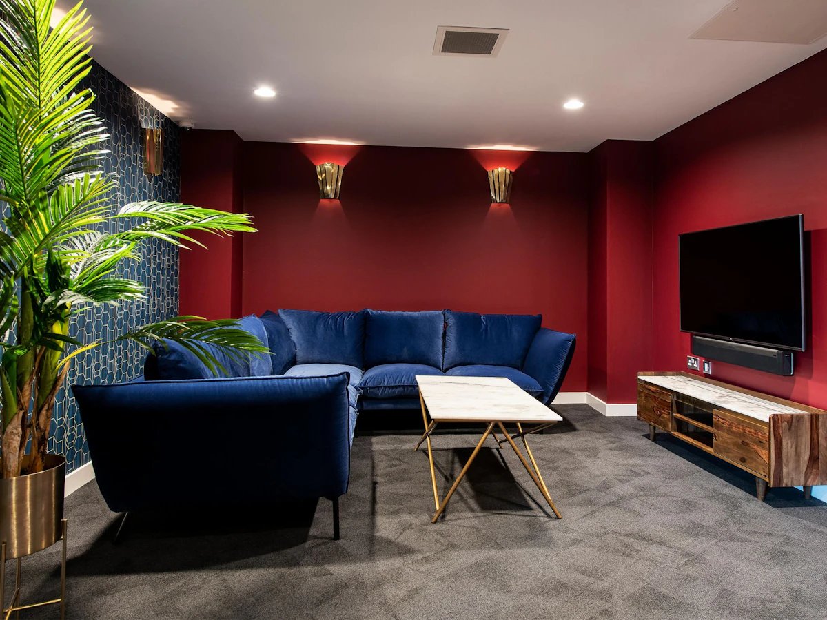Blue sectional sofa marble table television living room at Clifford House in Exeter Student Accommodation