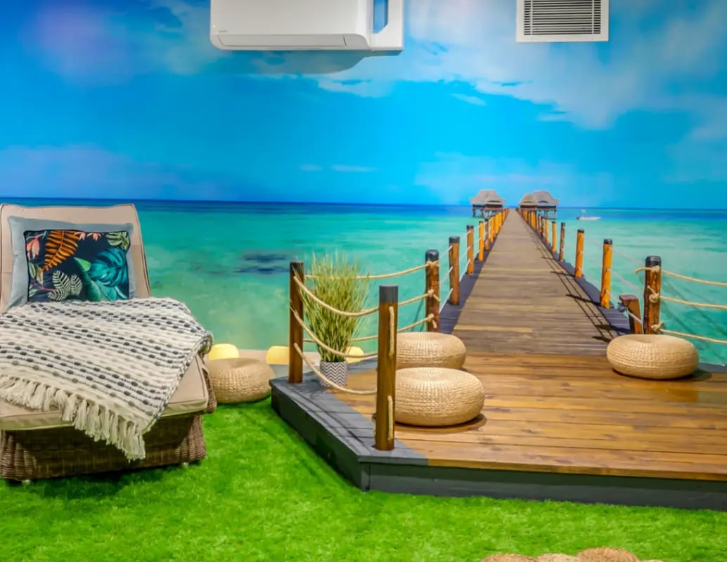 Chair blanket and pier with tropical backdrop living room at Gravity in Lincoln Student Accommodation