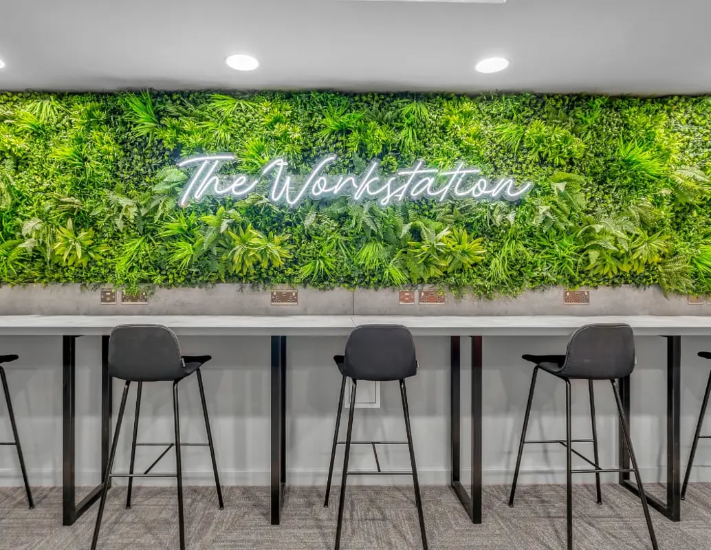 Green wall neon sign with bar stools study area at Gravity in Lincoln Student Accommodation