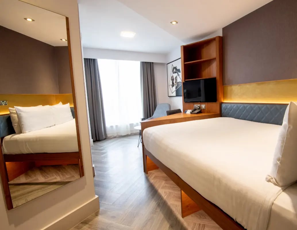 Bed TV desk and mirror student bedroom at IconInc London Stratford in London Student Accommodation