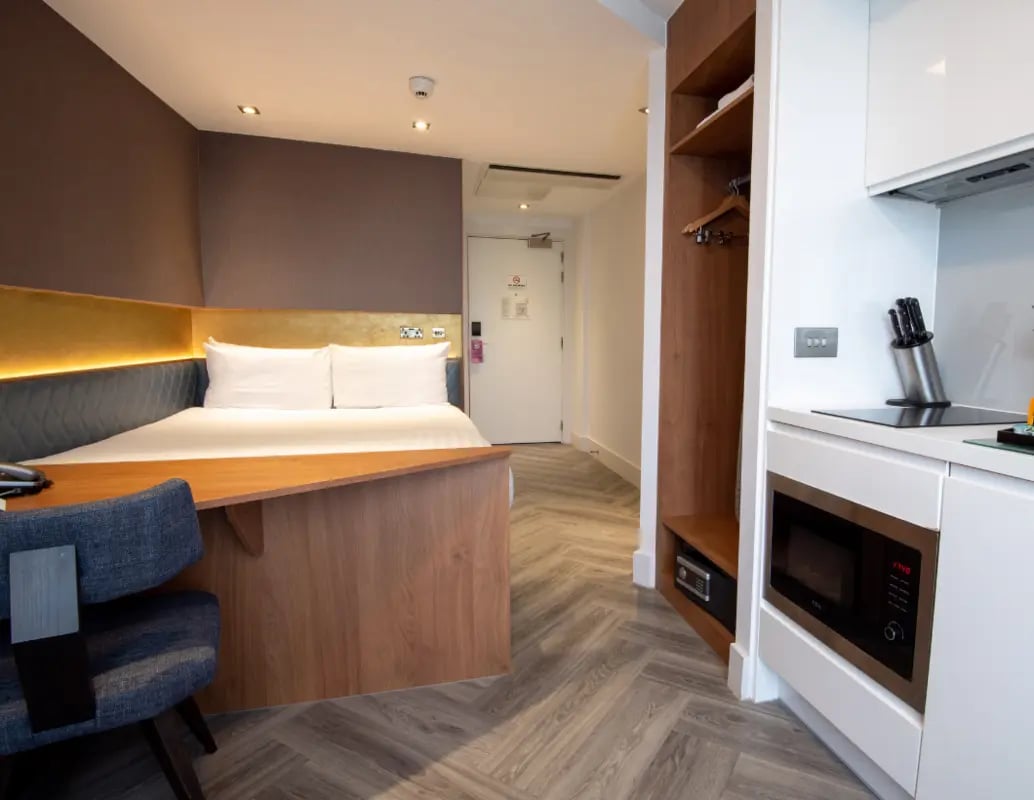 Bed desk chair microwave and shelving unit bedroom at IconInc London Stratford in London Student Accommodation