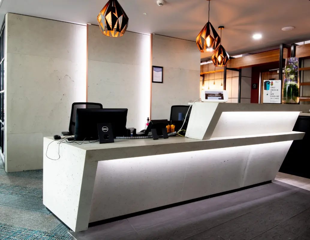 Reception desk with computers and modern lamps reception area at IconInc London Stratford in London Student Accommodation
