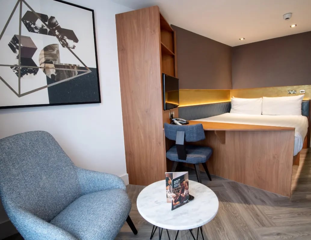 Bed desk chair with painting and chair Bedroom at IconInc London Stratford in London Student Accommodation