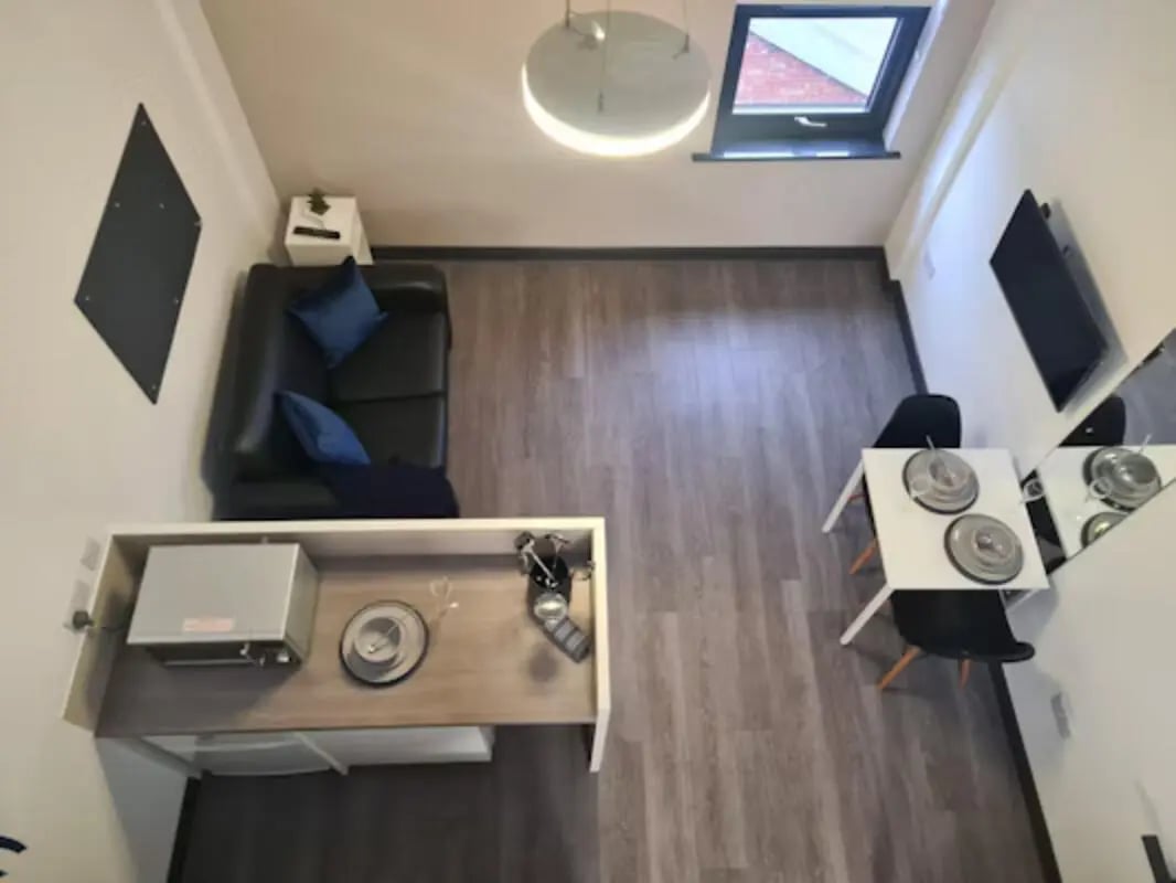Sofa table chairs and microwave studio apartment living room at St James House in Newcastle Upon Tyne Student Accommodation