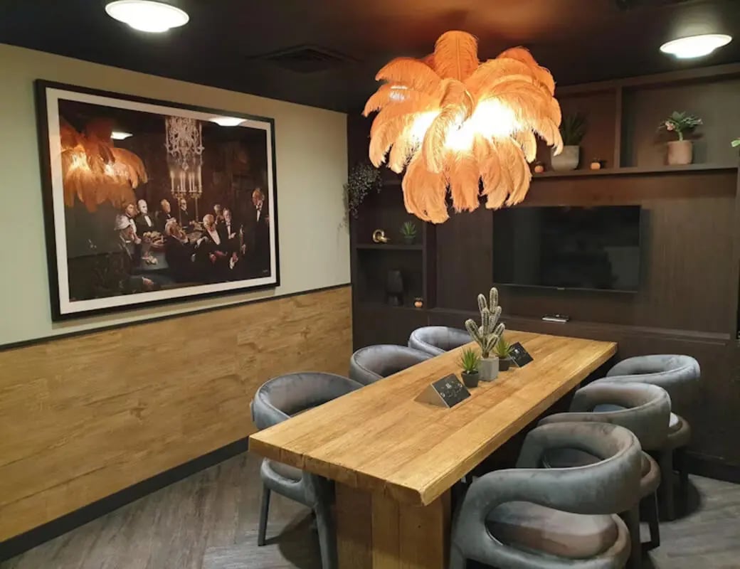 Dining table plush chairs artwork television lounge area at St James House in Newcastle Upon Tyne Student Accommodation