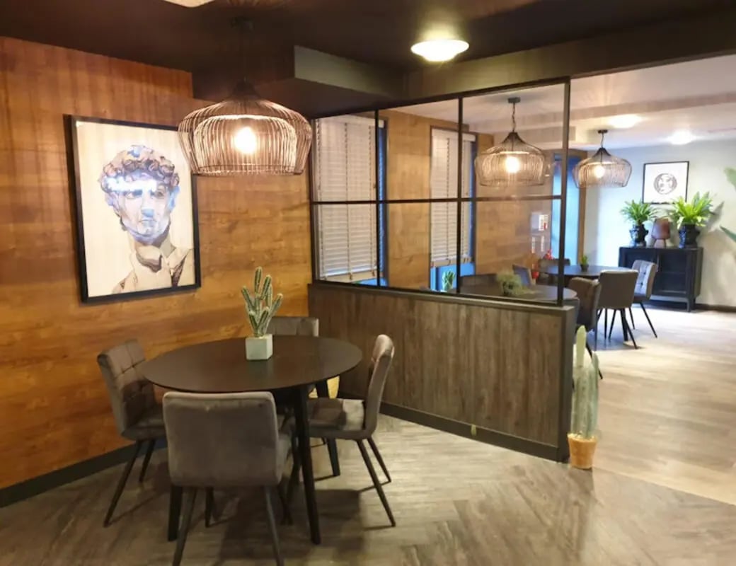 Round table, chairs, art, plants common area at St James House in Newcastle Upon Tyne Student Accommodation