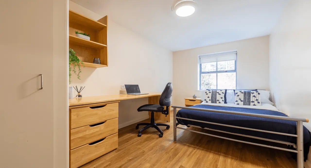 Bed desk shelving plants and laptop bedroom at dwell Hotwells House in Bristol Student Accommodation