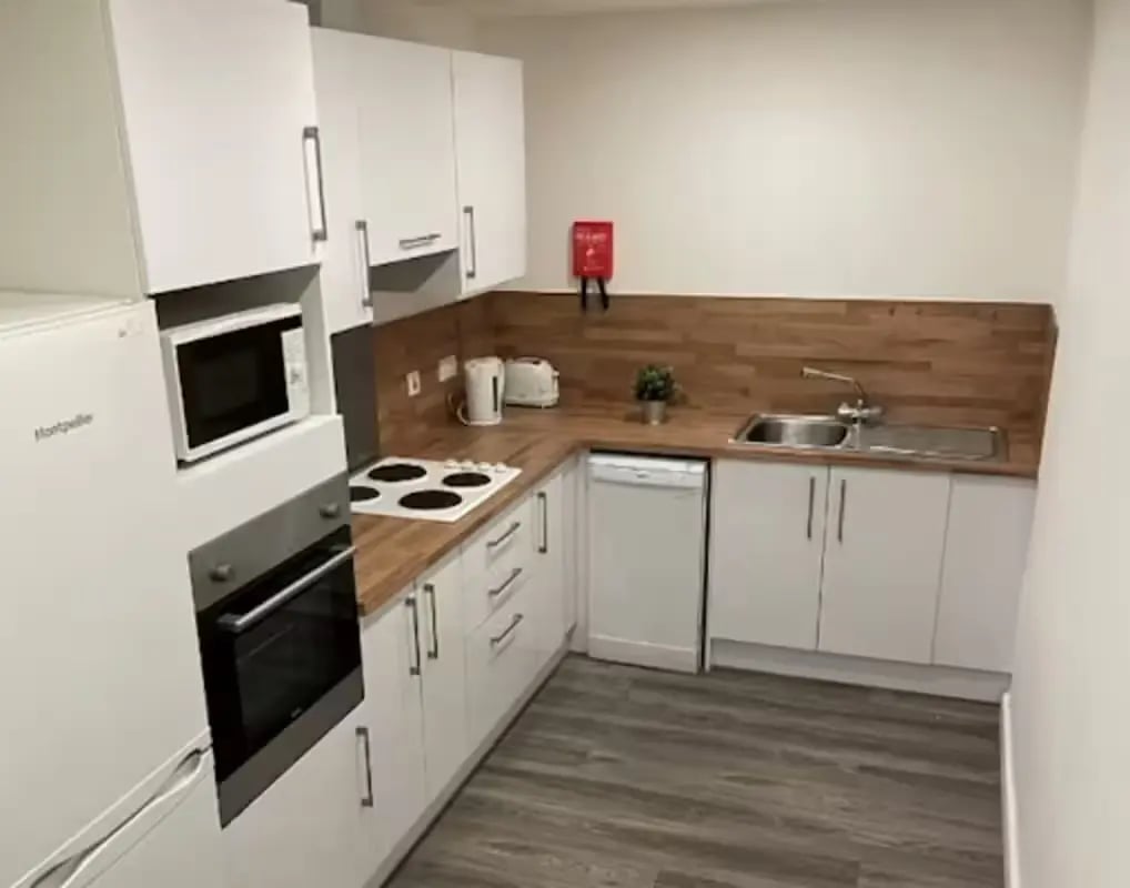White cabinets microwave oven stove sink kitchen at Page Apartments @ Central Place in Sheffield Student Accommodation