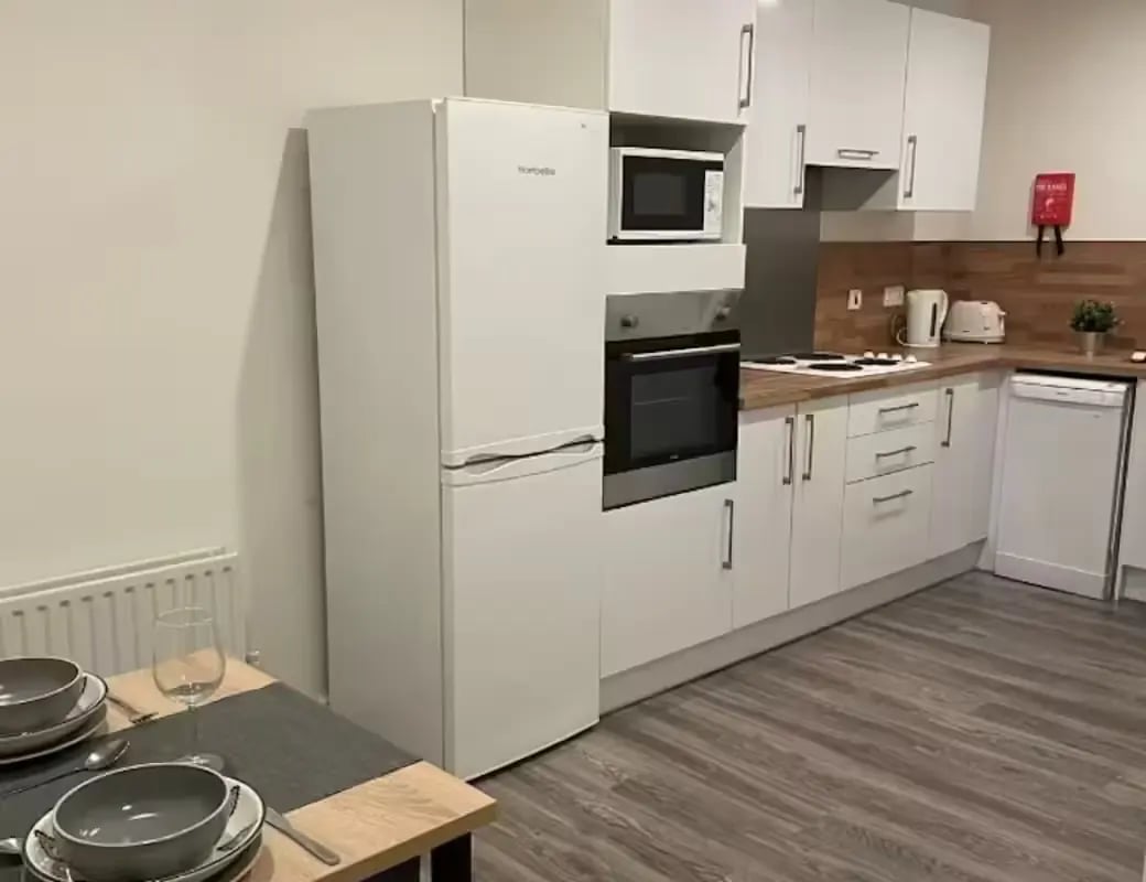 Modern white kitchen with oven fridge dishwasher kitchen area at Page Apartments @ Central Place in Sheffield Student Accommodation